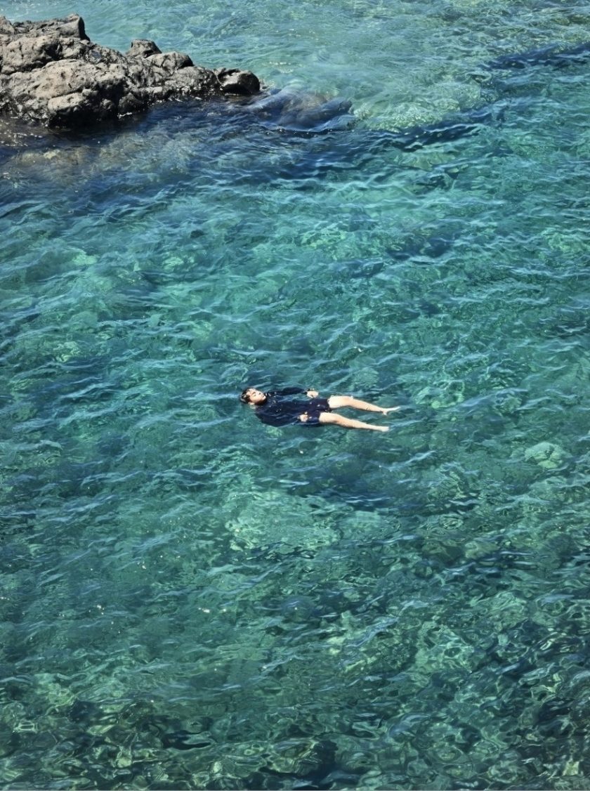 Person relaxing in volcanic natural pool in La Palma